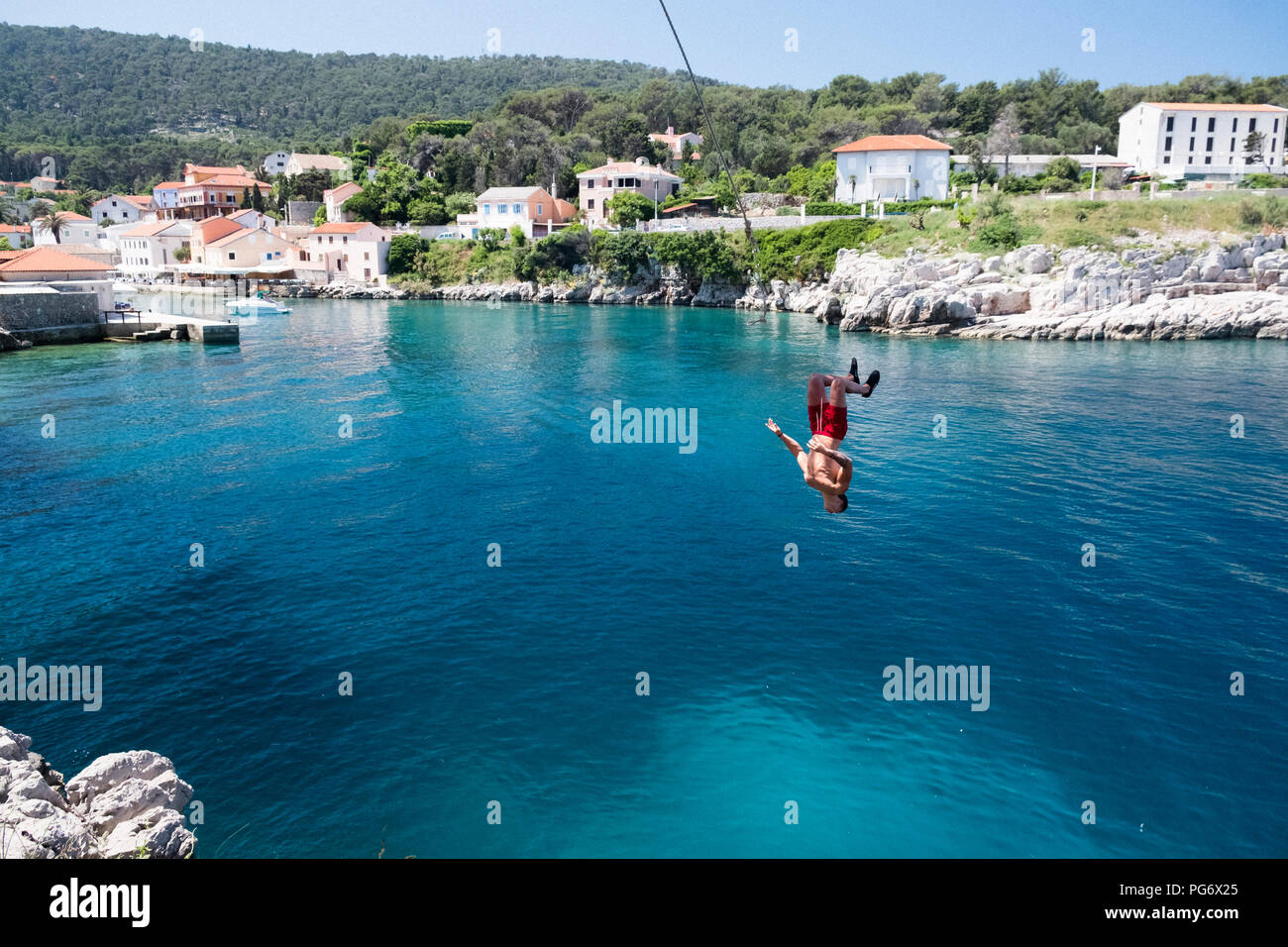 La Croatie, Istrie, Losinj, Rovenska, jeune homme bungee jumping Banque D'Images