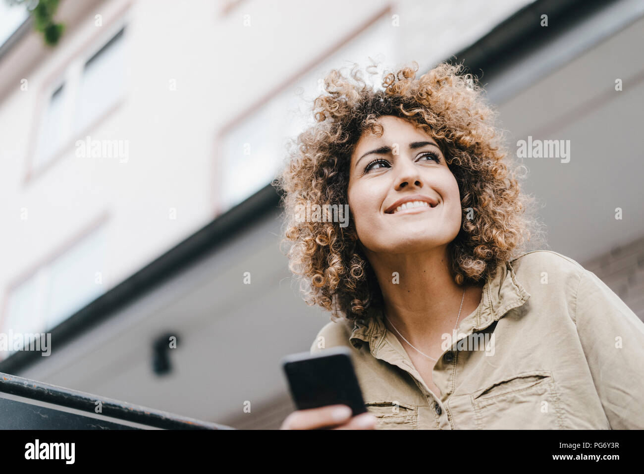 Femme dans la ville using smartphone Banque D'Images