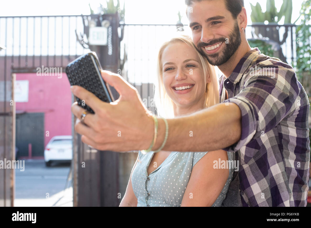 Heureux jeune homme avec une petite amie selfies Banque D'Images