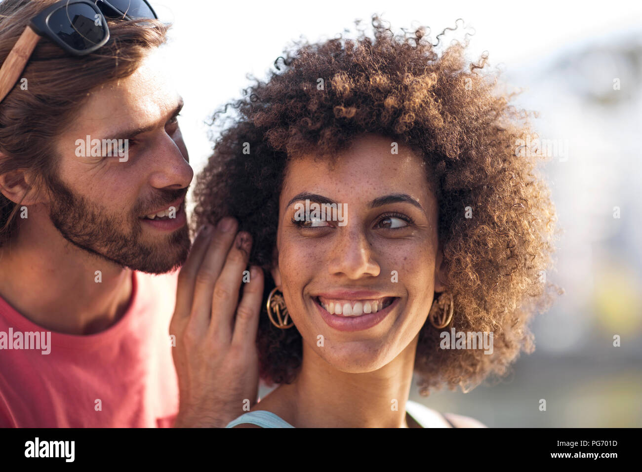 Happy young couple homme femme, chuchotant à l'oreille Banque D'Images