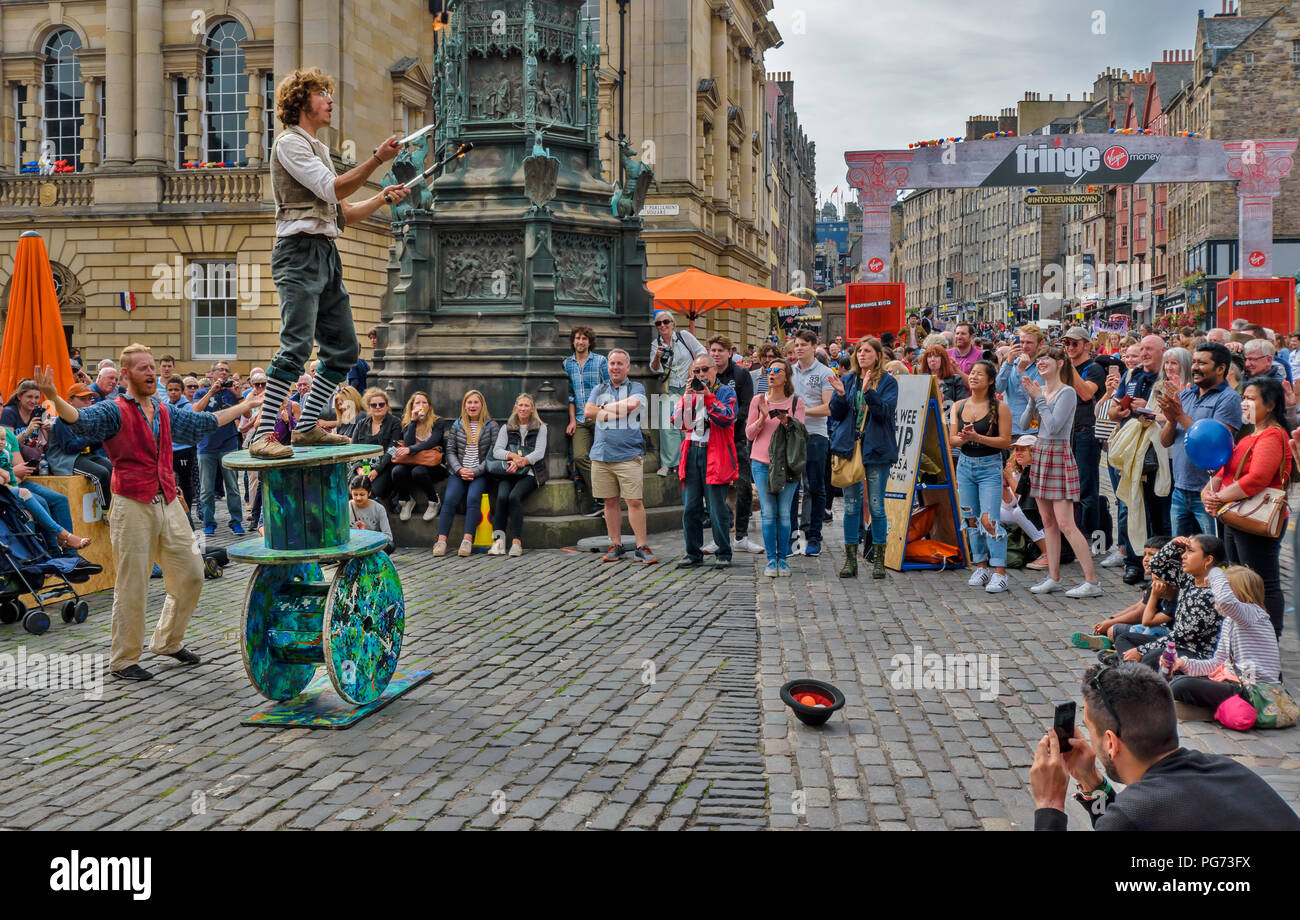 EDINBURGH FESTIVAL FRINGE 2018 FIRE JUGGLER en équilibre sur de grandes bobines en bois Banque D'Images