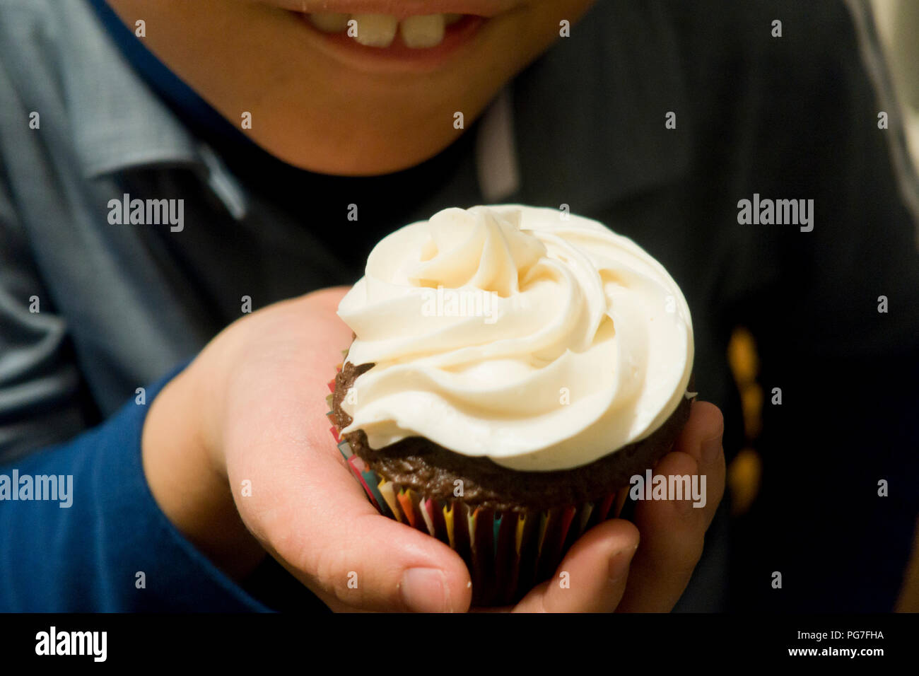 Enfant tenant avec glaçage cupcake fait maison tourbillonné - USA Banque D'Images