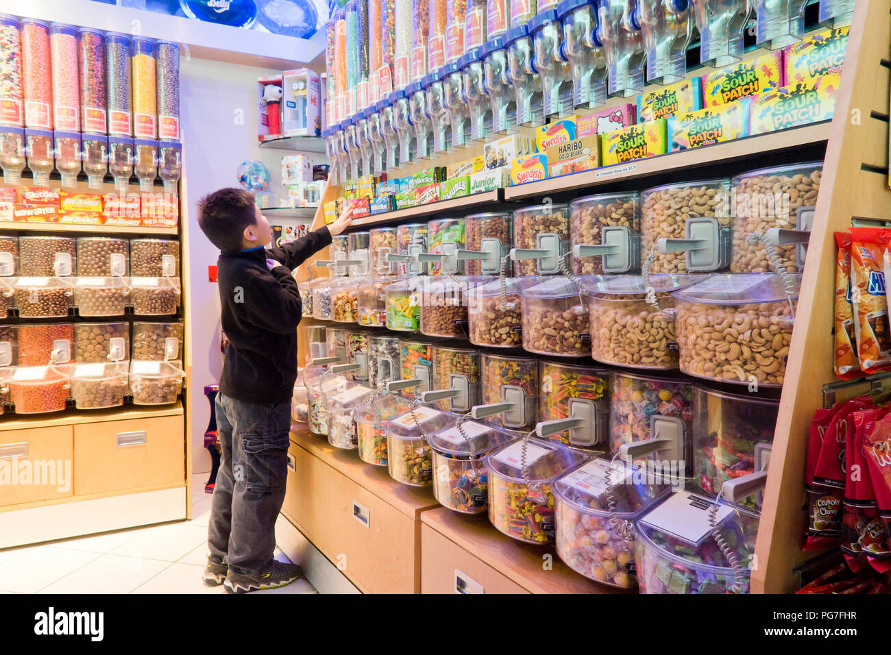 Enfant, âgé de 8 ans, l'achat de bonbons à un magasin de bonbons (sweet shop) - USA Banque D'Images