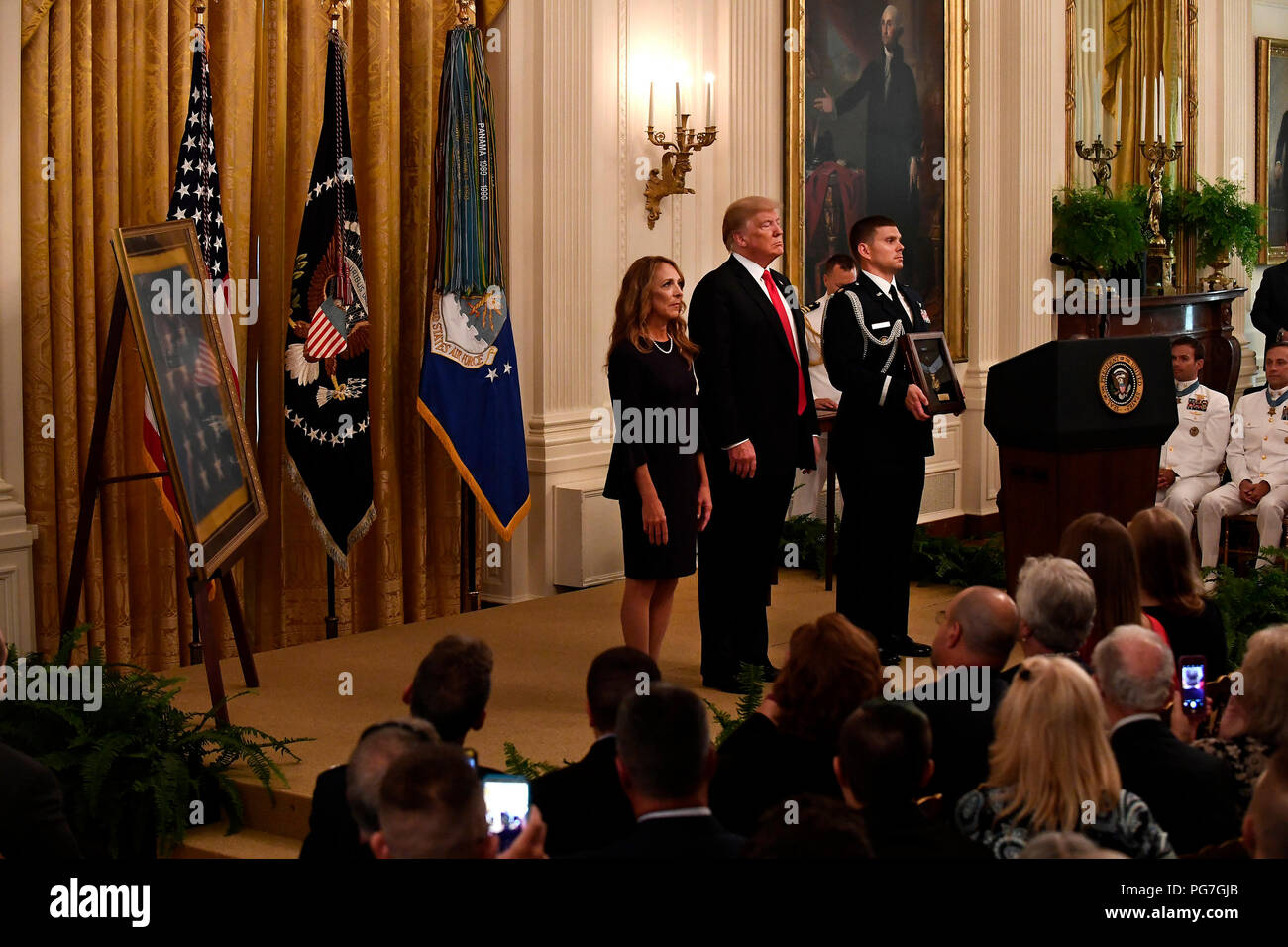 Valerie Nessel, le conjoint de l'US Air Force Tech. Le Sgt. John Chapman, se distingue comme la citation est lue avant de recevoir la médaille d'honneur du président Donald J. Trump lors d'une cérémonie à la Maison Blanche à Washington, D.C., le 22 août, 2018. Le sergent Chapman a reçu à titre posthume la Médaille d'Honneur pour des actions sur Takur Ghar mountain en Afghanistan le 4 mars 2002. Son équipe d'élite des opérations spéciales est tombé dans une embuscade tendue par l'ennemi et est venu sous un feu nourri provenant de multiples directions. Chapman immédiatement débité un ennemi par bunker-cuisse de la neige profonde et a tué tous les occupants de l'ennemi. Movin avec courage Banque D'Images