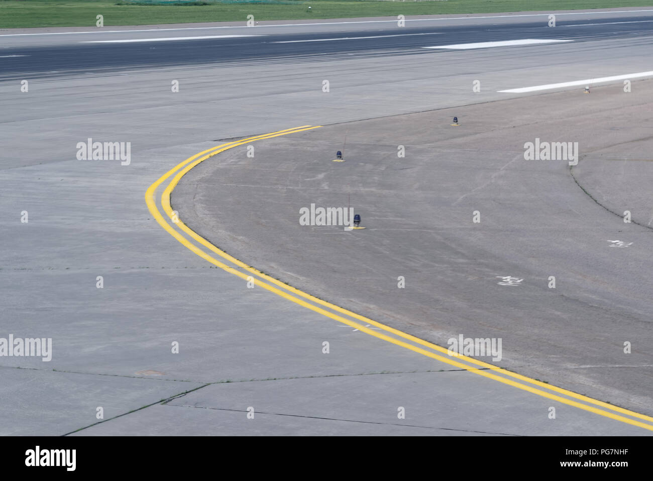 La courbe de la piste à l'aéroport avec double ligne jaune Banque D'Images