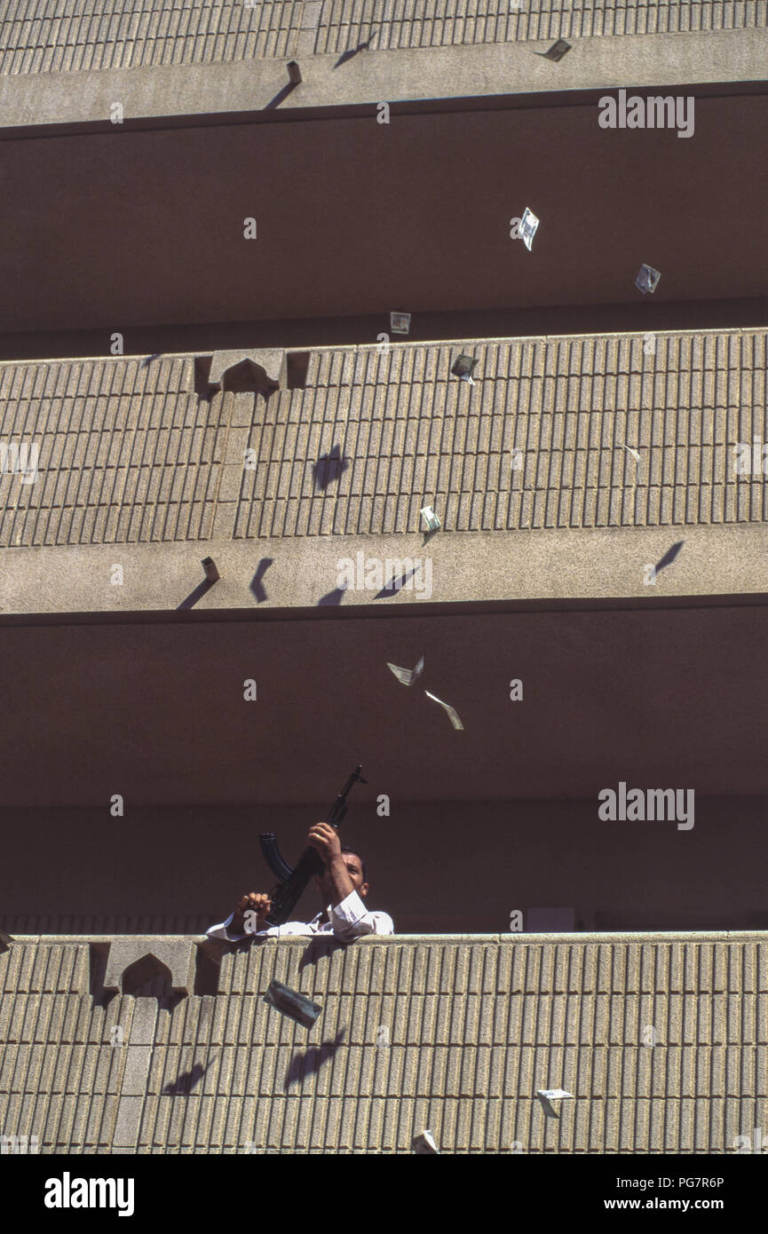 Pistolet de tir irakien joyeuse de son bloc d'appartement balcon, en célébration du Président Saddam Hussein victoire écrasante à l'élection du candidat unique avec une seule question, 'vous approuver de Saddam Hussein en tant que président de la République ?' oui ou non d'un référendum, dont il a gagné 99,6  %. Banque D'Images