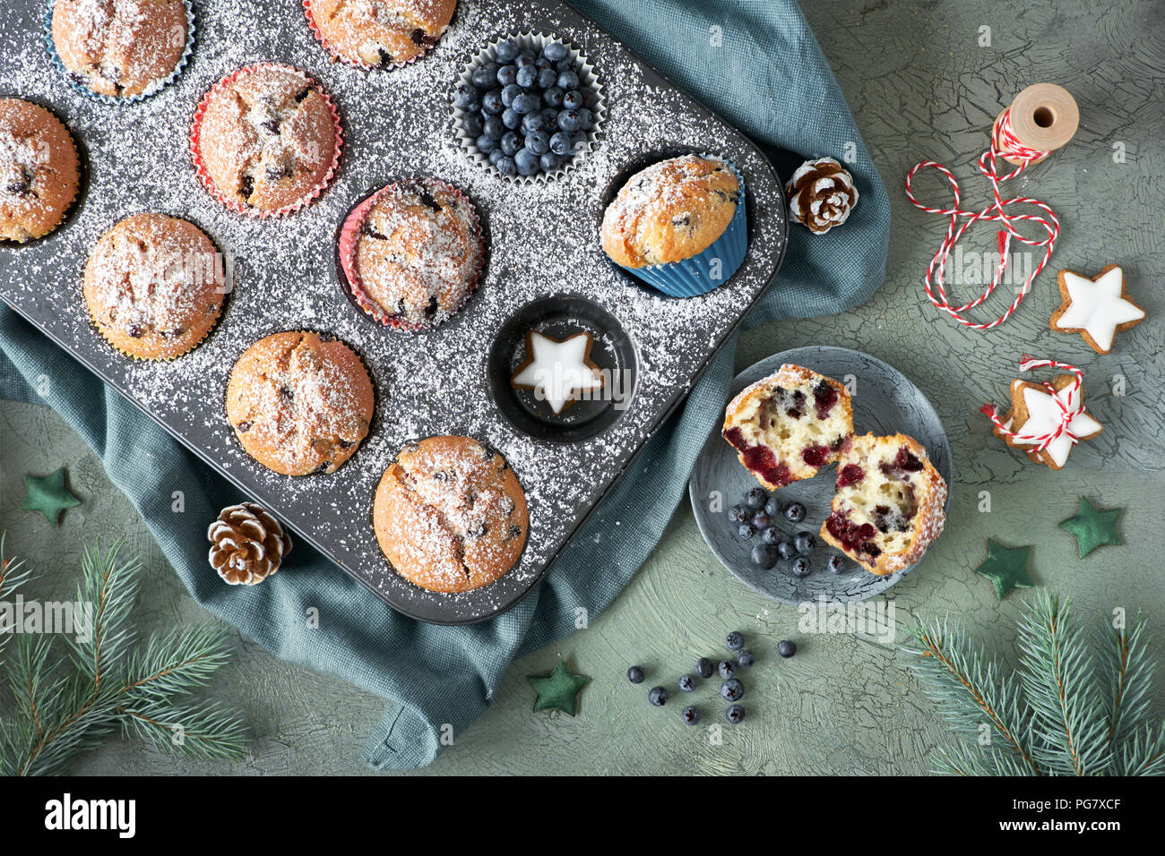 Muffins aux bleuets avec givrage sucre dans une plaque à pâtisserie avec les décorations de Noël autour de lay, télévision, vue de dessus Banque D'Images