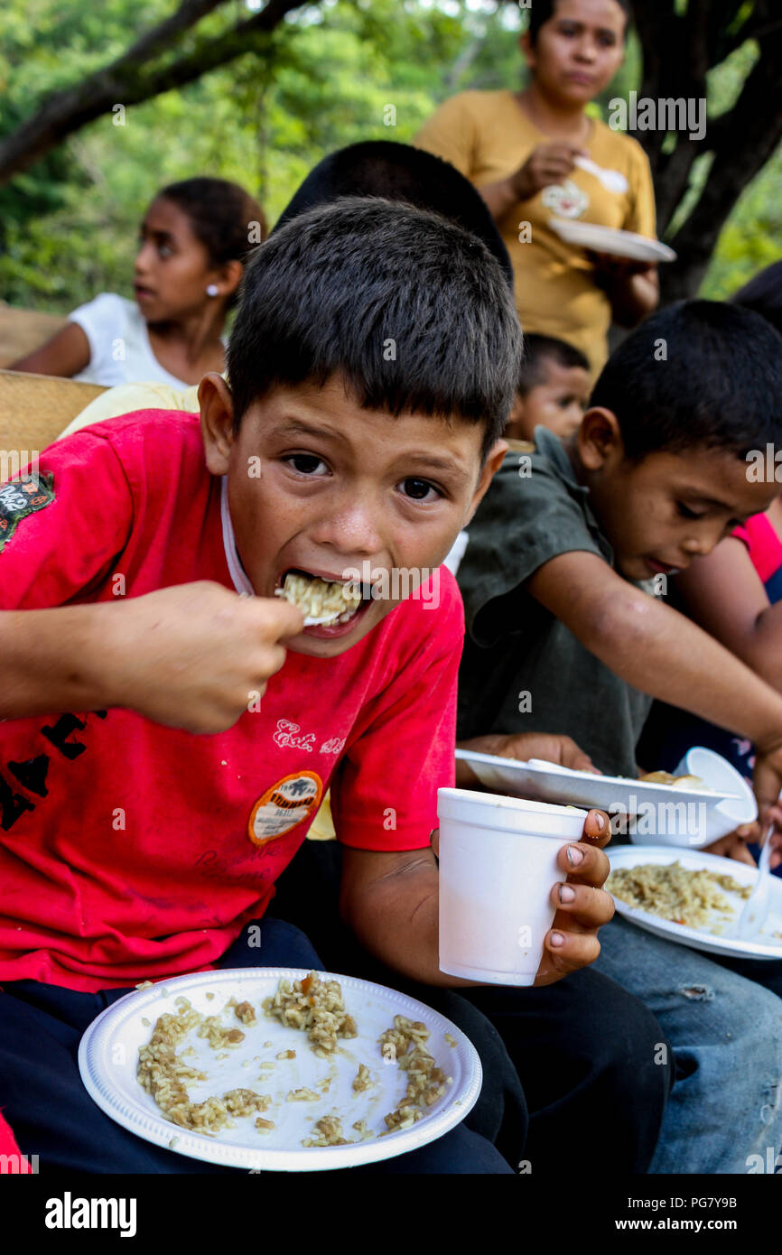 Managua, Nicaragua - 11 mai 2017 : Les enfants mangent un repas de riz enrichis offerts par missionnaires américains à leur église au Nicaragua. Banque D'Images