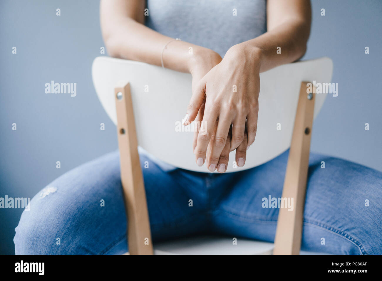 Mains d'une femme assise sur une chaise Banque D'Images