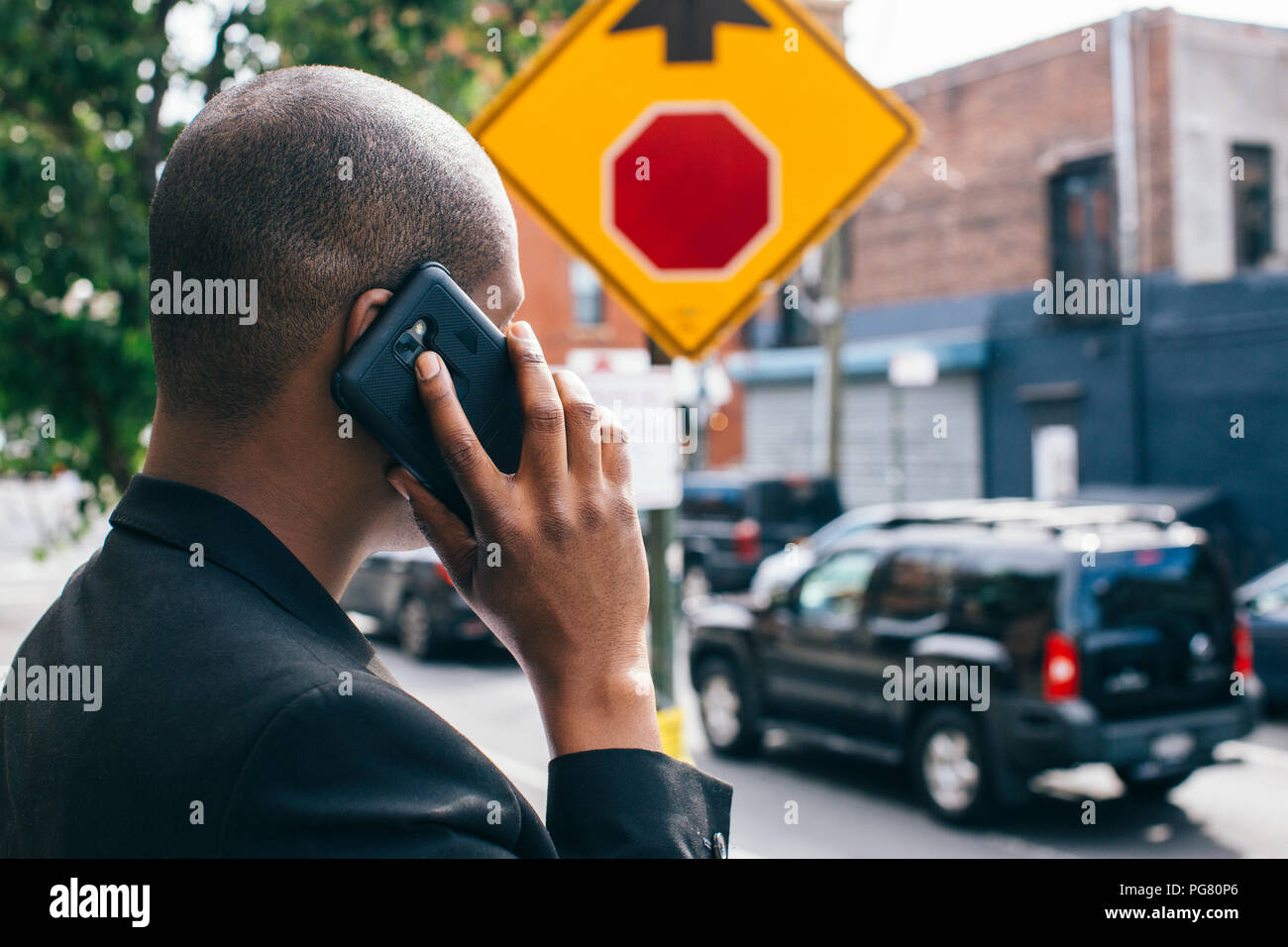 Homme debout au bord de la route, à parler au téléphone Banque D'Images