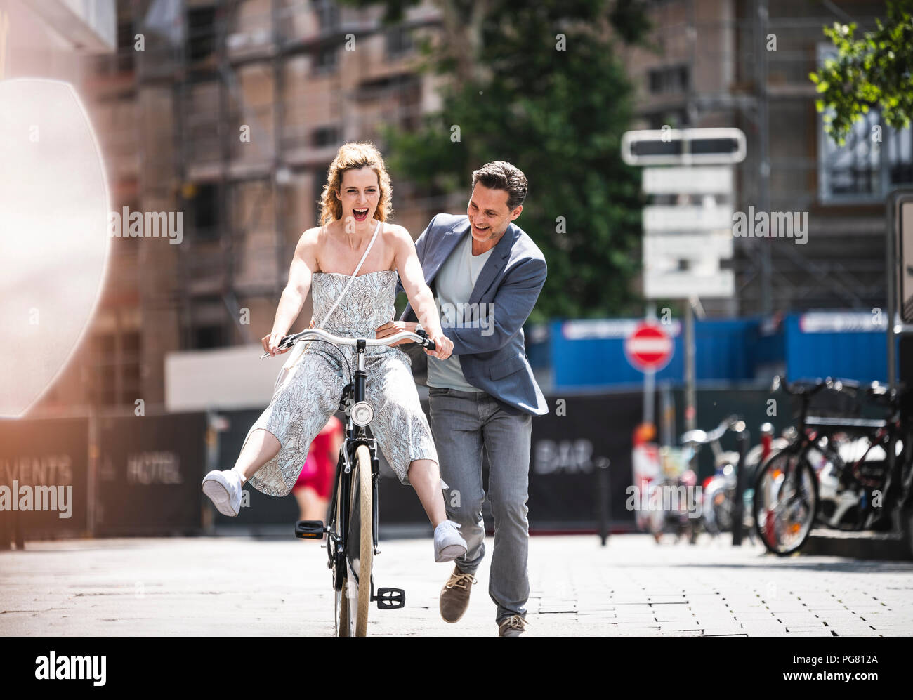 Carefree couple heureux avec vélo dans la ville Banque D'Images