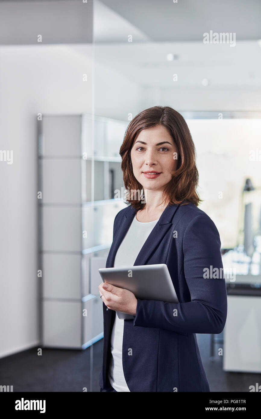 Portrait of smiling young businesswoman with tablet in office Banque D'Images