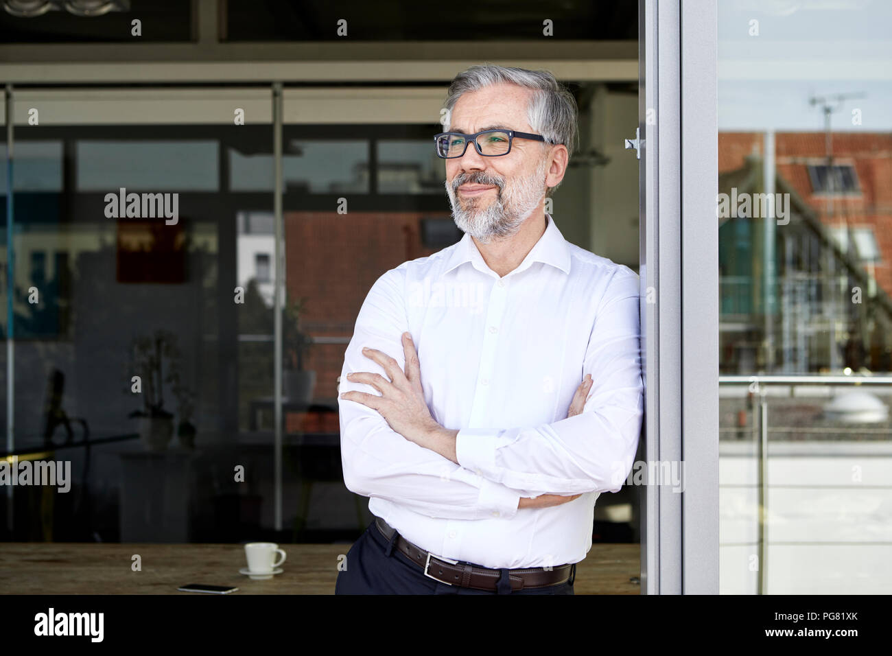 Smiling businessman standing at porte française de penser Banque D'Images