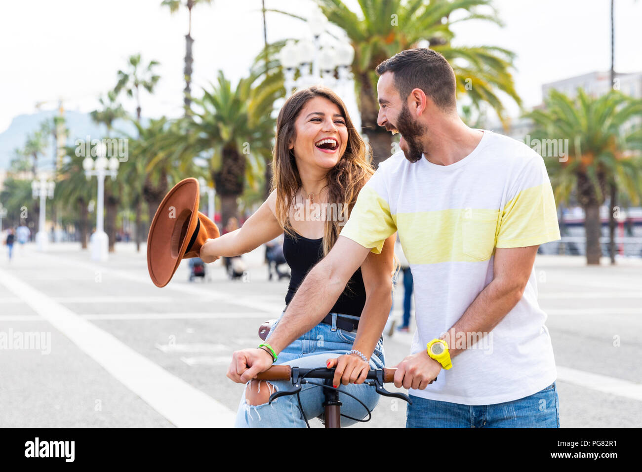 Espagne, Barcelone, couple et le partage d'un trajet sur un vélo ensemble à la promenade du bord de mer Banque D'Images