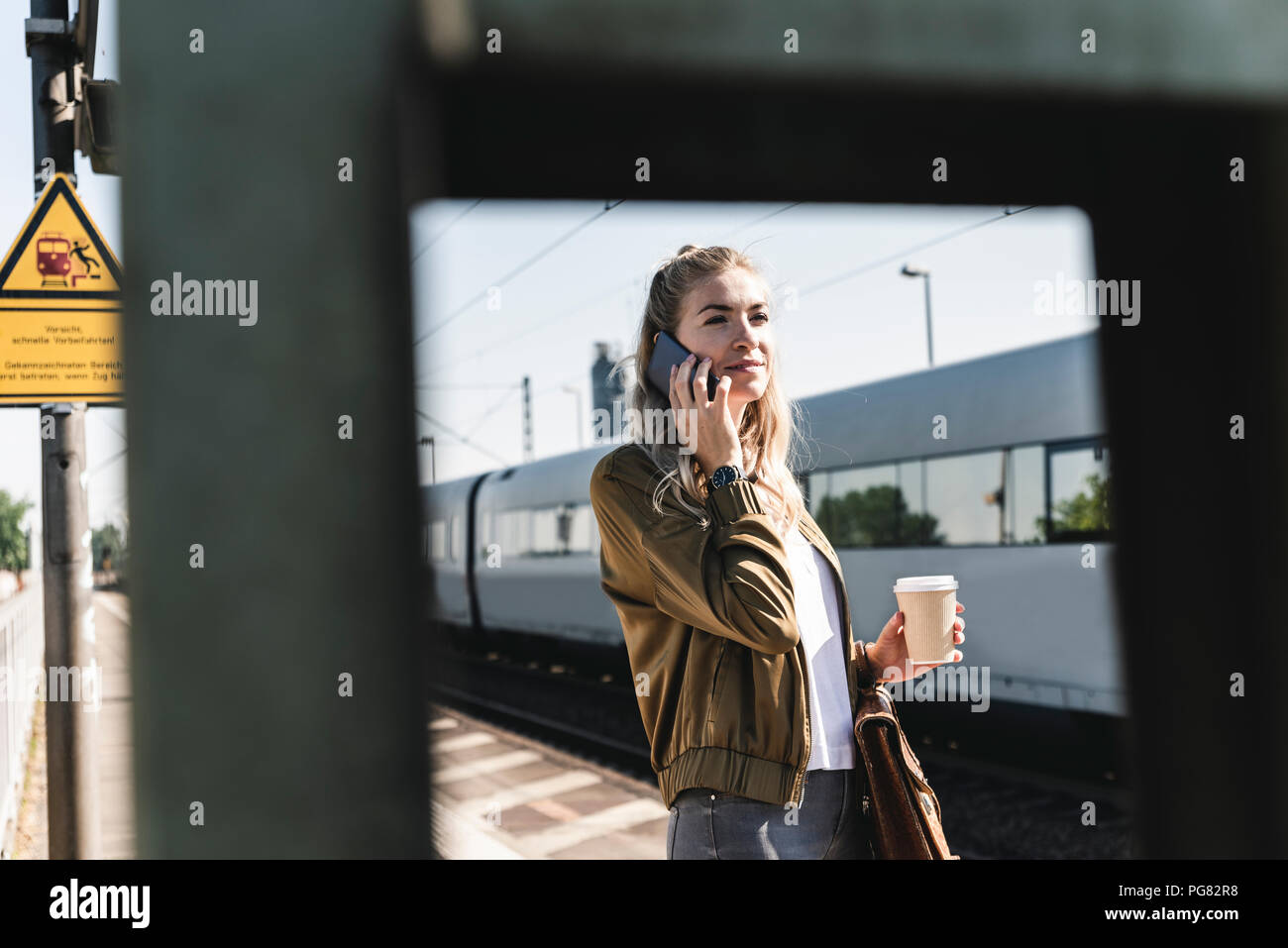 Jeune femme à la gare parler au téléphone Banque D'Images