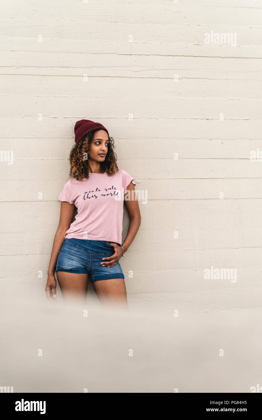 Portrait of a young woman leaning against wall Banque D'Images