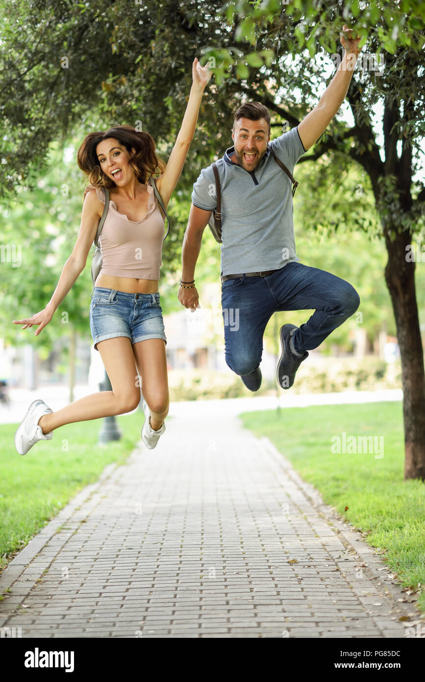 Carefree couple jumping in park Banque D'Images