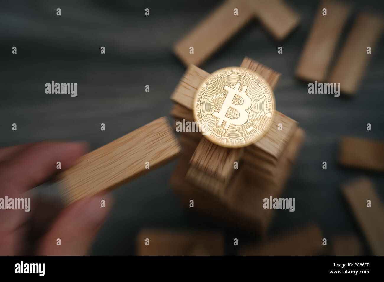 Sur le Bitcoin blocs de construction en bois de la tour part le déplacement d'un bloc. Effet de flou de zoom. Notion de risque bitcoin. Banque D'Images