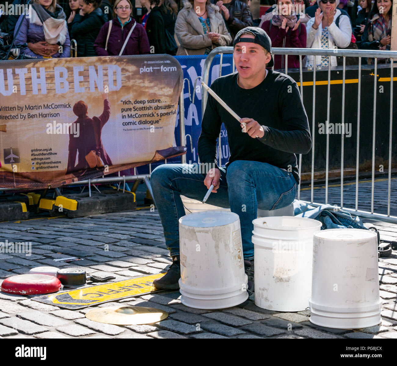 Edinburgh Fringe Festival, Édimbourg, Écosse, Royaume-Uni. 24 août 2018. Le soleil brille sur les festivaliers et un artiste de rue à la Vierge de l'argent liens sponsorisés street sur le Royal Mile. Un musicien ambulant de rue appelé le godet Boy, alias Matthieu jolie, batterie sur les seaux et les casseroles et autres objets Banque D'Images