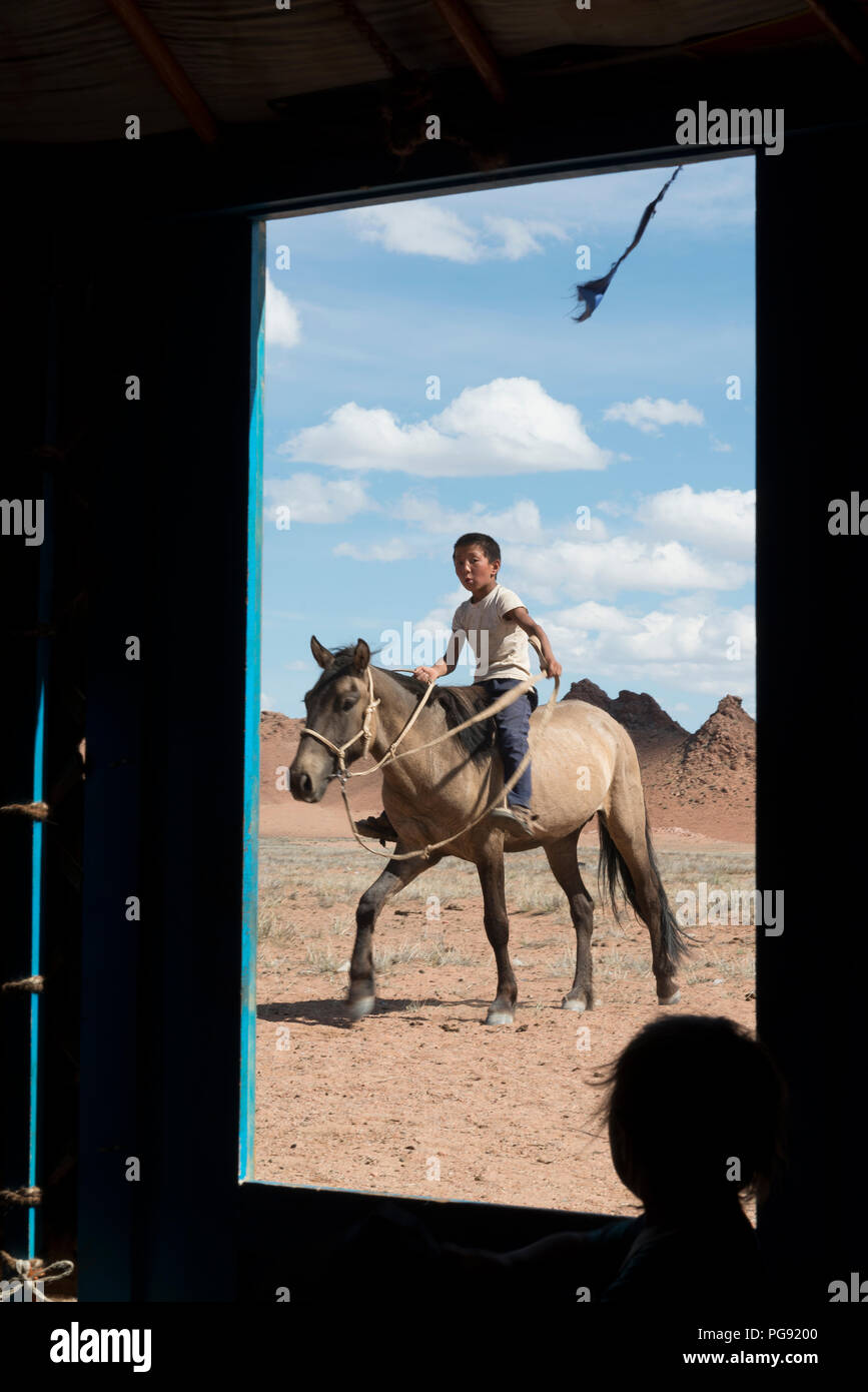 Boy arrivés à sa famille' s ger à cheval. La Mongolie Banque D'Images