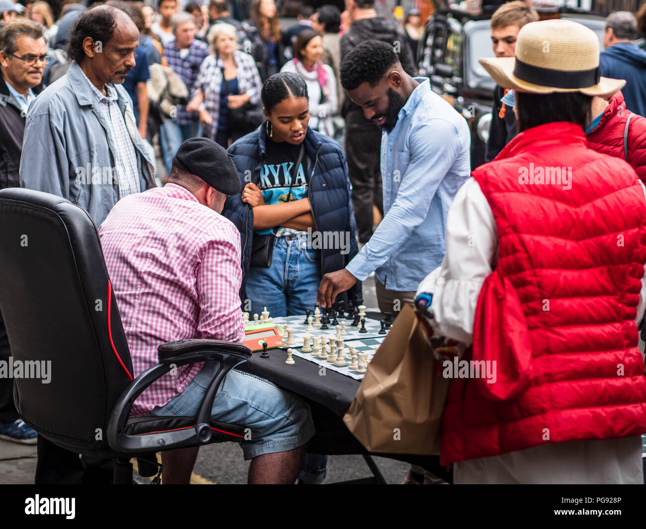 Brick Lane London Street Chess - un joueur d'échecs joue 4 matches simultanés avec les touristes et les passants dans le célèbre marché du dimanche Brick Lane de Londres Banque D'Images