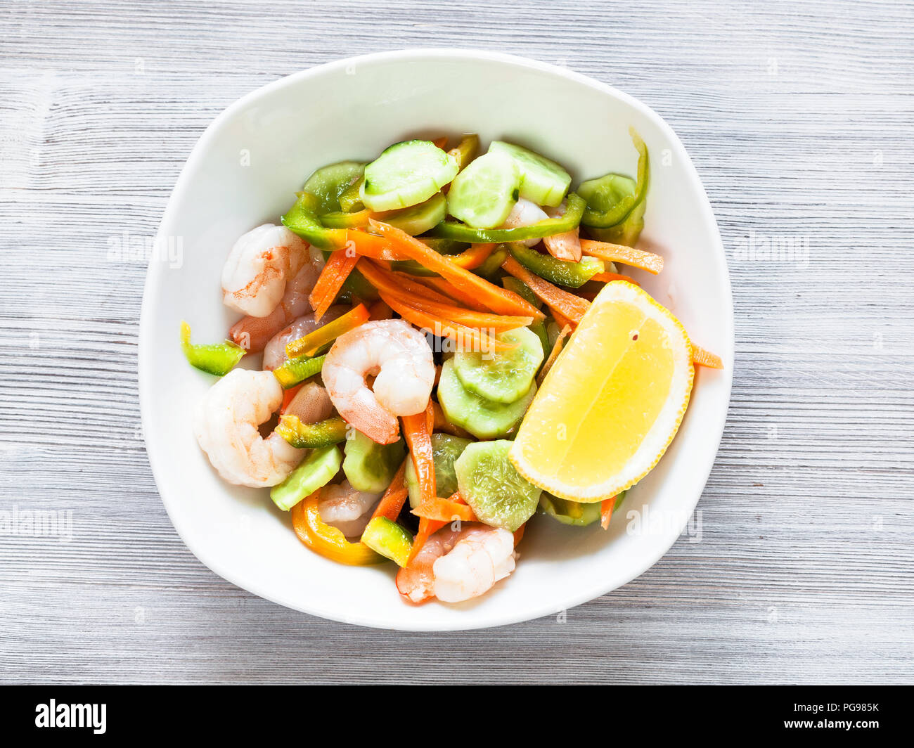 La cuisine indienne - salade de langoustines de légumes et les crevettes dans un bol blanc sur la table gris Banque D'Images