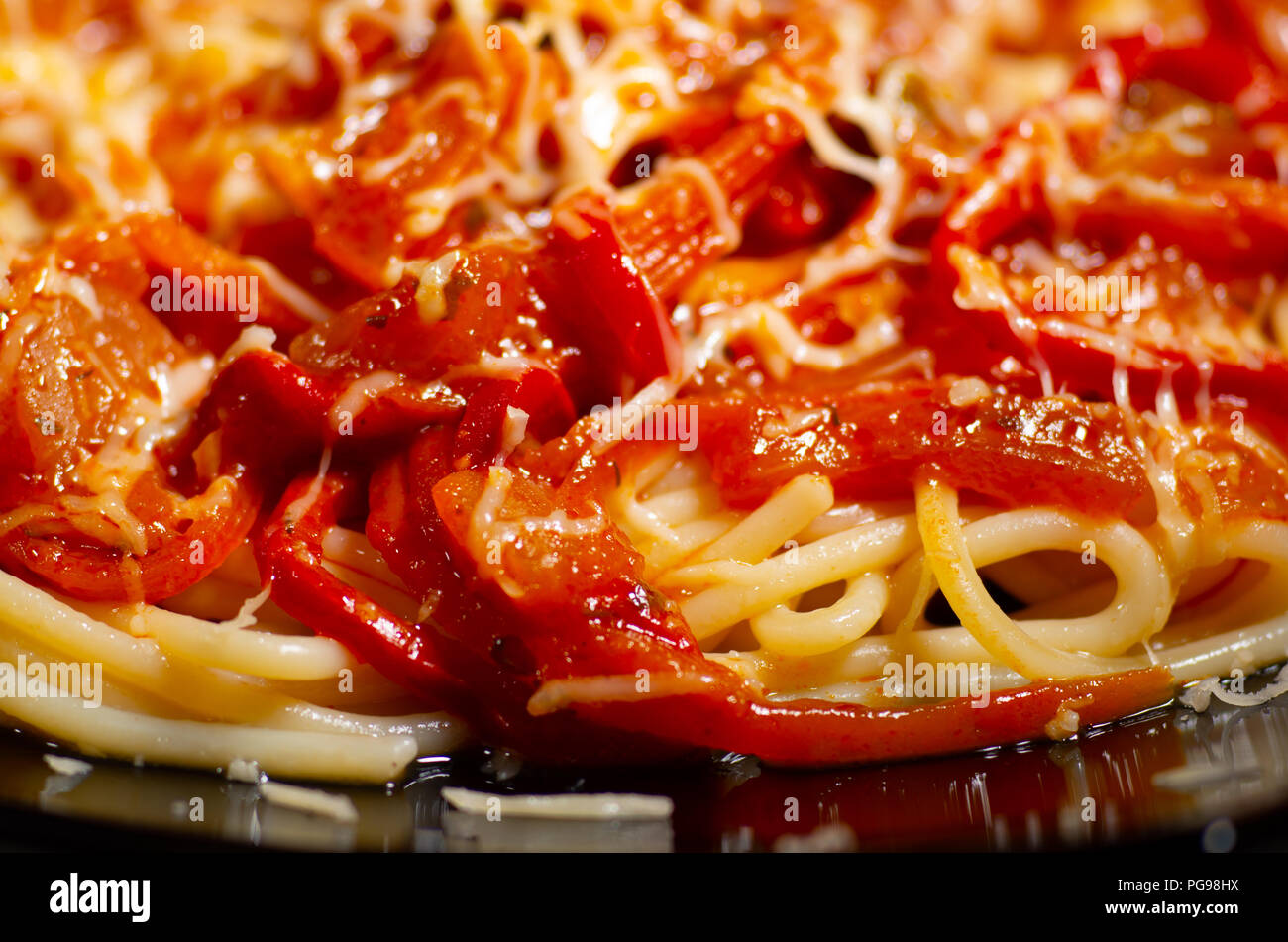 Vue détaillée d'un plat de spaghetti italien avec assaisonnement de ragoût de légumes et fromage close-up avec pour arrière-plan flou Banque D'Images