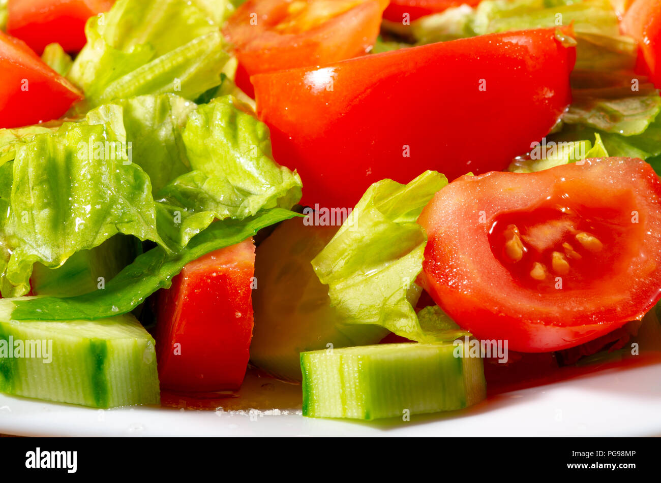 Mélanger les légumes frais de tranches de concombres, tomates, épinards et laitue close-up avec blur. Banque D'Images