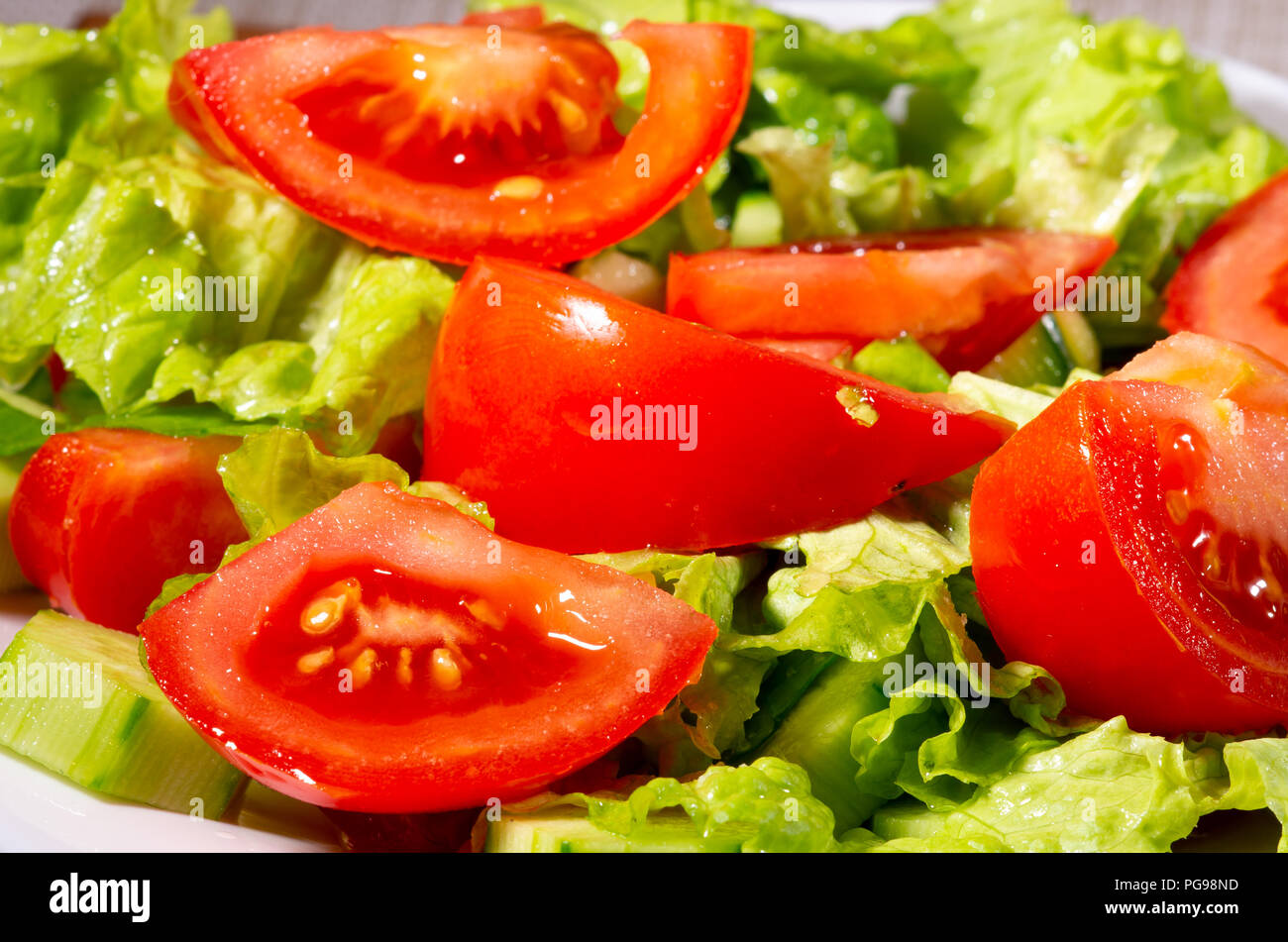 Fragment de plat fait à partir de morceaux de concombres, tomates, épinards et laitue close-up avec blur. Banque D'Images
