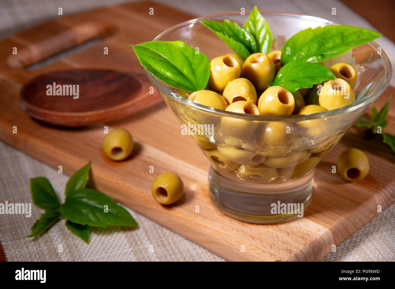 Olives vertes dans une tasse en verre sont versées à l'huile d'olive Banque D'Images