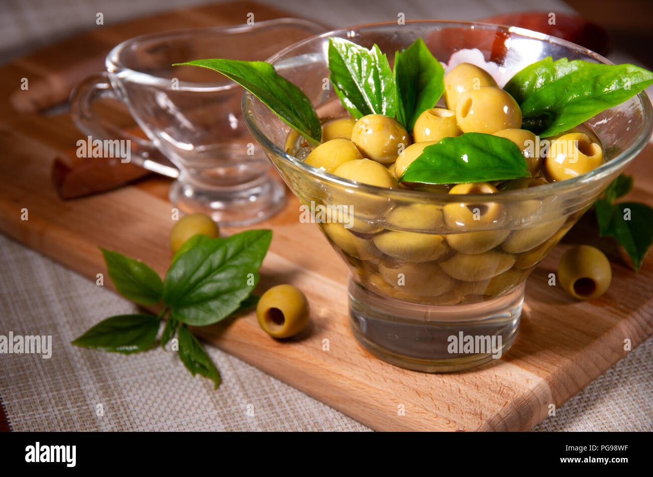 Olives vertes dénoyautées dans une tasse en verre sont versées à l'huile d'olive Banque D'Images