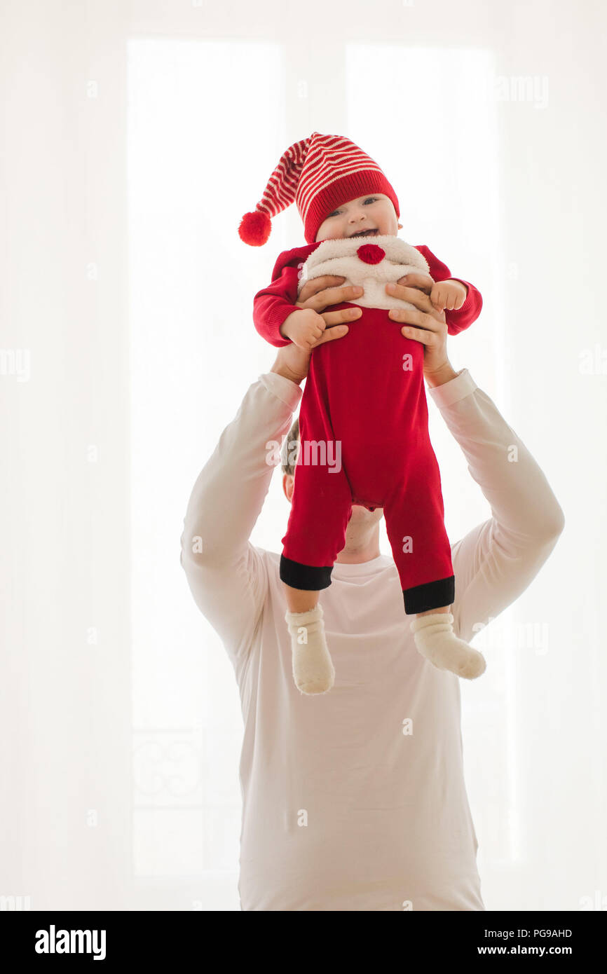 Young man holding baby in Christmas romper Banque D'Images