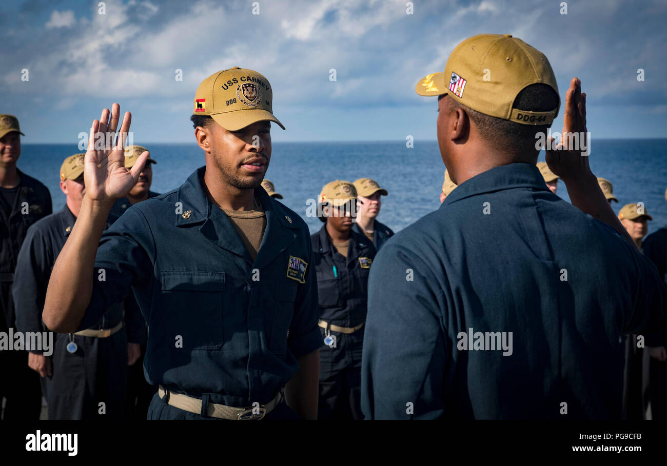 180821-N-U653-181 MER NOIRE (Aug. 21, 2018) Le Cmdr. Chris Carroll, directeur général de la classe Arleigh Burke destroyer lance-missiles USS Carney (DDG 64), rend le serment de réinscription au technicien de systèmes d'information en chef Tyrone Davis le 21 août 2018. Carney, l'avant-déployé à Rota, en Espagne, est sur sa cinquième patrouille dans la sixième flotte américaine zone d'opérations à l'appui d'alliés et de partenaires régionaux ainsi que les intérêts de sécurité nationale des États-Unis en Europe et en Afrique. (U.S. Photo par marine Spécialiste de la communication de masse 1re classe Ryan U. Kledzik/libérés) Banque D'Images