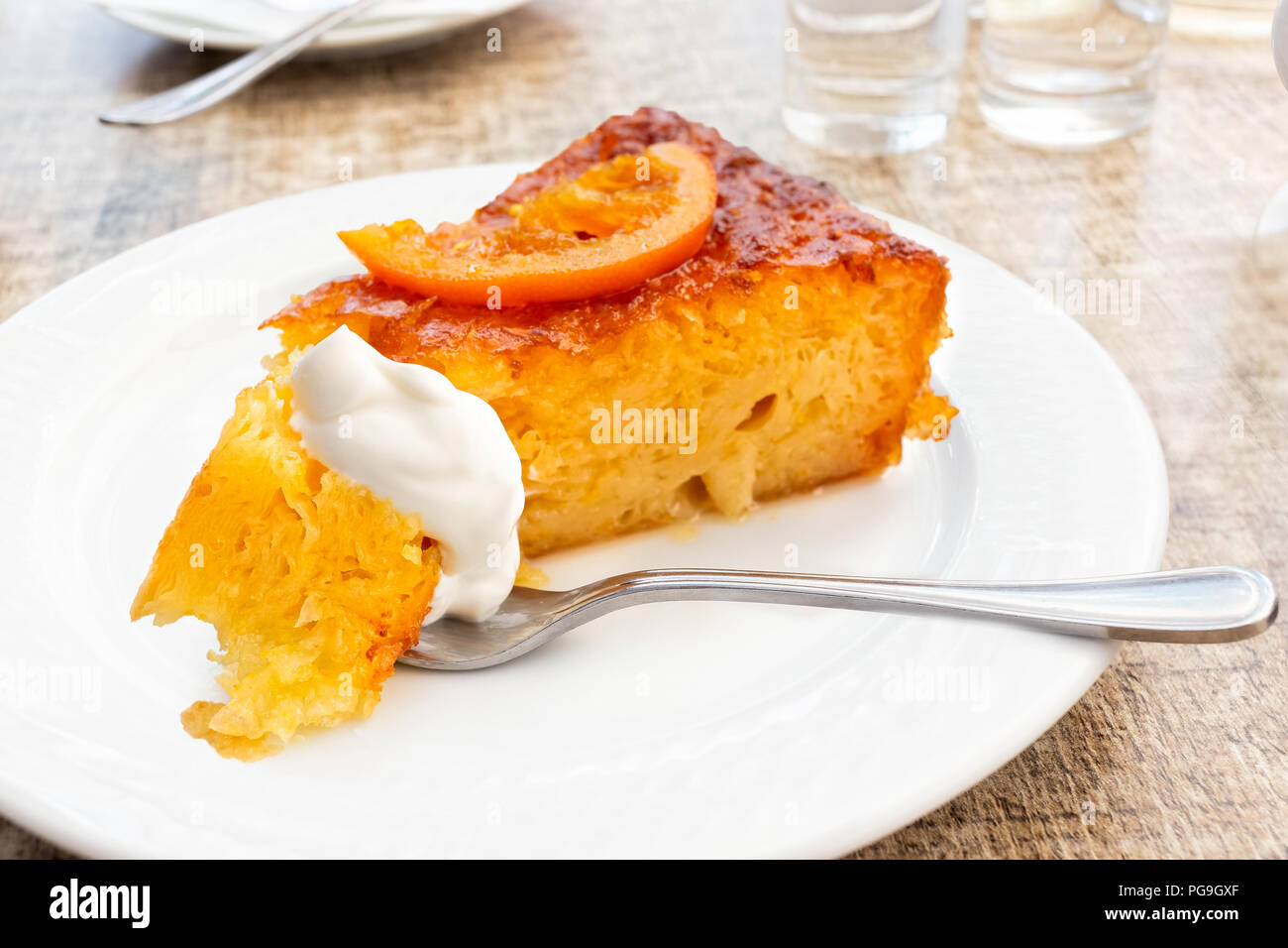 Un Morceau De Gateau Orange Traditionnel Grec Sur Plaque Blanche Une Bouchee De Gateau Et De Creme Sure Sur Fourche Photo Stock Alamy