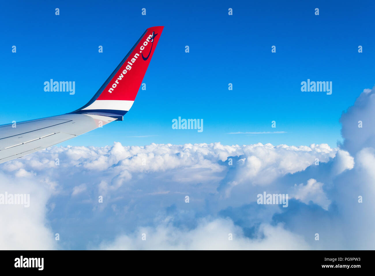 L'avion de Londres Gatwick à Mallorca en Espagne par Norwegian Air Shuttle. Vue depuis la fenêtre sur l'aile d'avion au-dessus de nuages avec ciel bleu . Banque D'Images