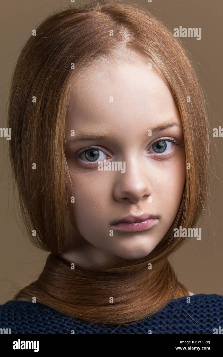 Close-up portrait of beautiful young redhead en studio sur fond beige Banque D'Images