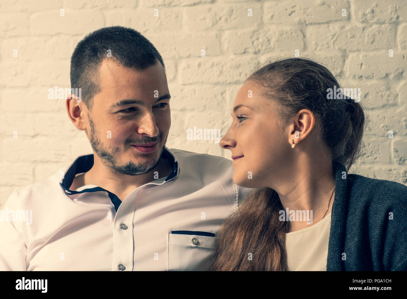 La fille et le gars dans un café, à une table, de parler. Le gars et la fille avec amour et tendresse se regardent. Banque D'Images