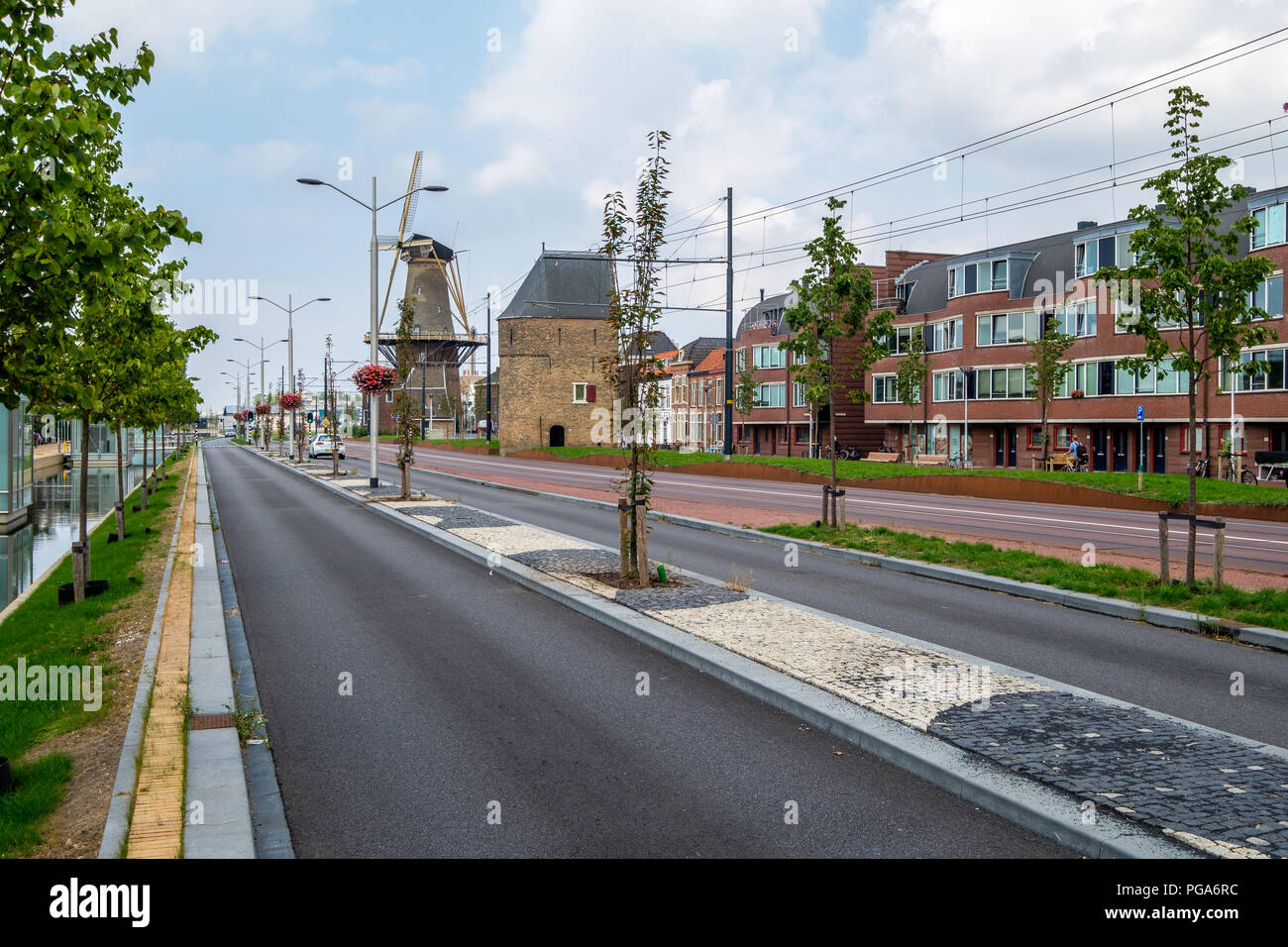 Un nouveau tramway le long de l'ancien moulin de la ville, Delft, Pays-Bas. Banque D'Images