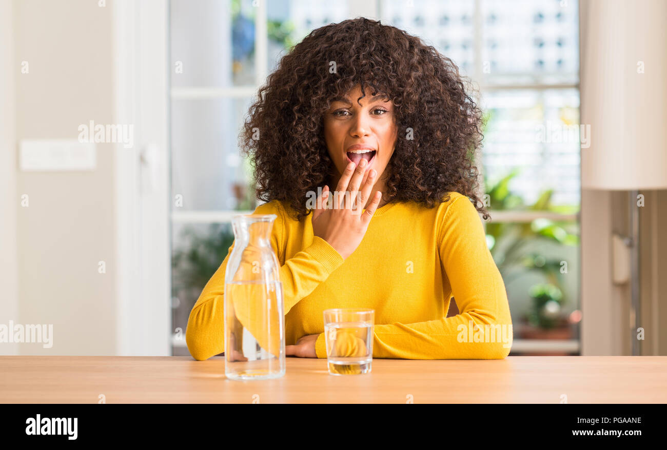 African American Woman boire un verre d'eau à la bouche avec couvercle part choqué avec honte pour erreur, expression de la peur, peur en silence, Banque D'Images