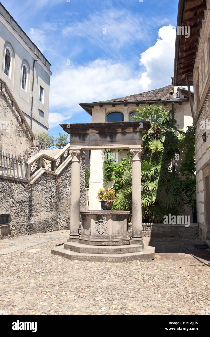 Vieux puits dans la Piazza Cesare Augusto Tallone sur le chemin du silence, Isola San Giulio, lac d'Orta, Italie. Banque D'Images