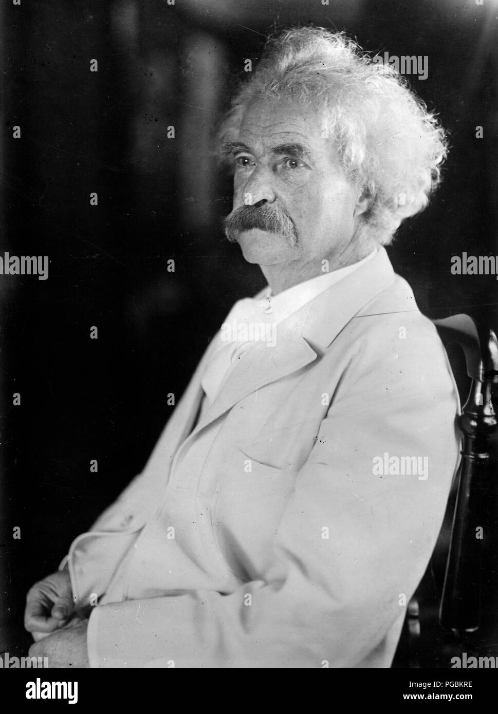 Samuel Clemens (Mark Twain) assis dans fauteuil Banque D'Images