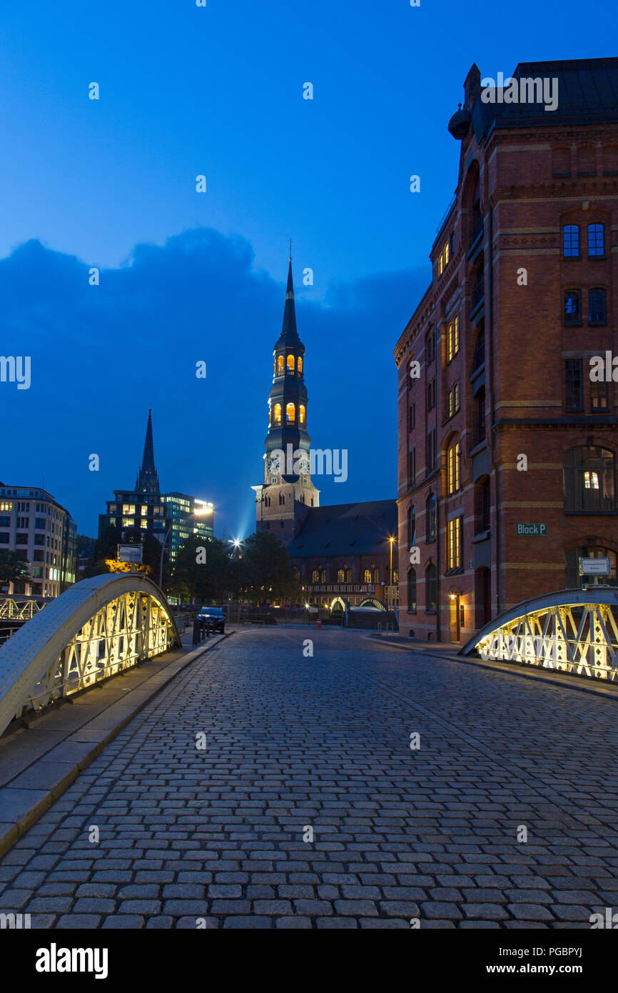 Pont avec des pavés et Hauptkirche Sankt Katharinen la nuit, Speicherstadt, district dans le quartier Hafencity, port de Hambourg, Allemagne Banque D'Images