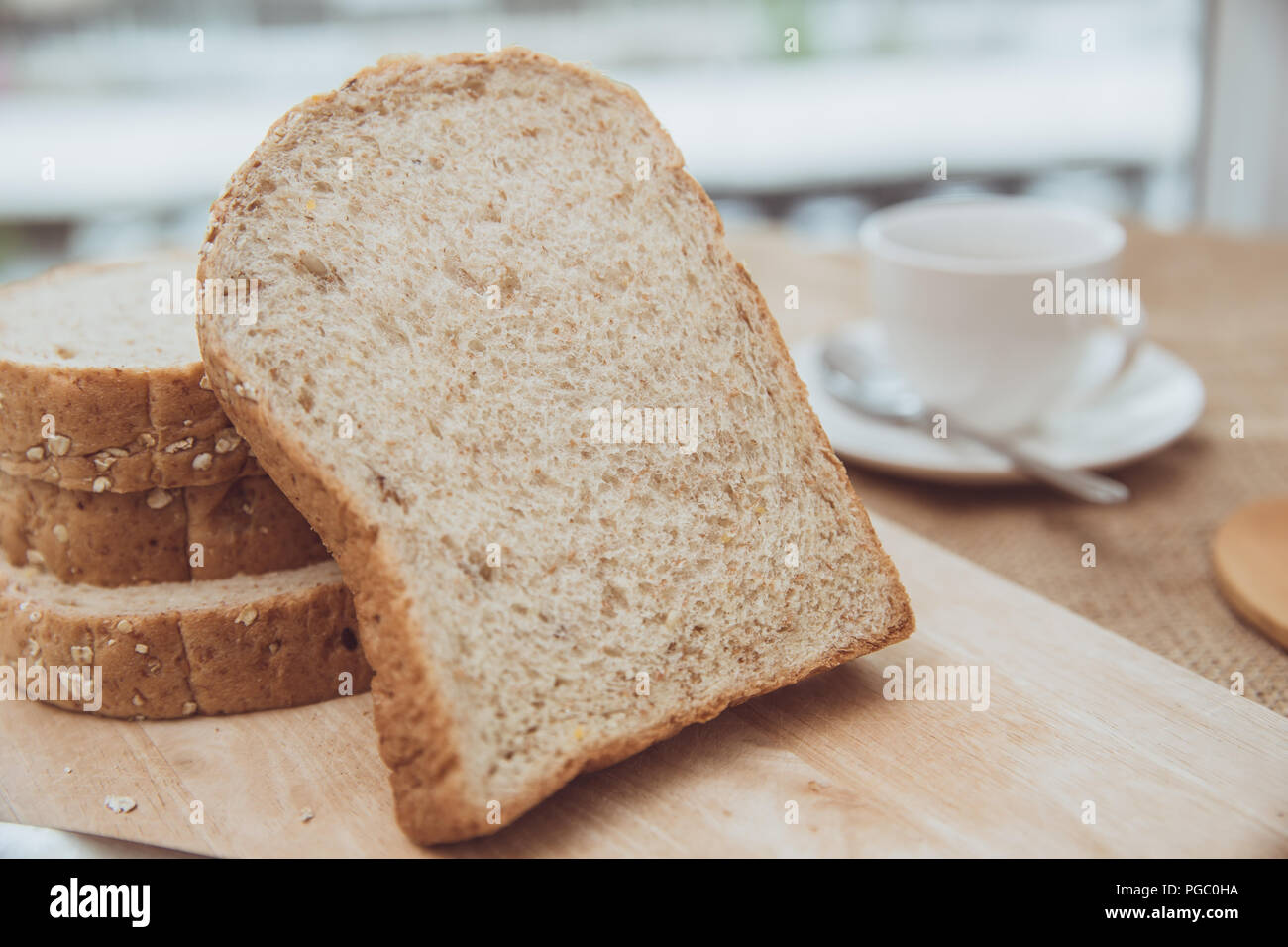 Le pain de grains entiers sur table en bois repas du matin avec café vintage color tone Banque D'Images