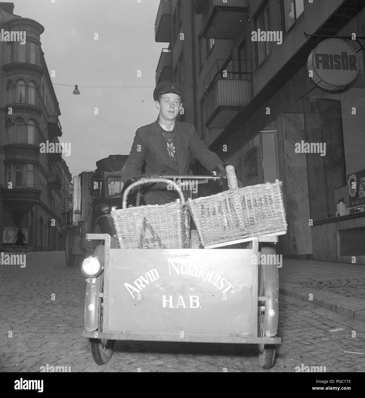 1940s transport à vélo. Un homme qui travaille comme livreur avec des provisions sur son vélo pour être livré aux clients de la société Arvid Nordquist. Suède 1942. Photo Kristoffersson A125-2 Banque D'Images