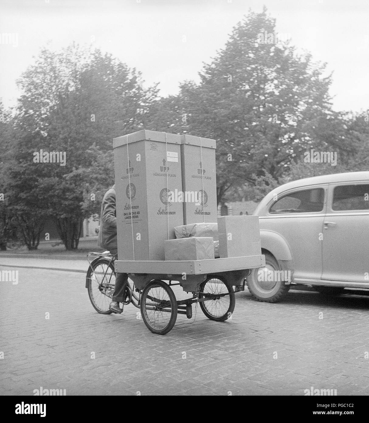 transport des années 1950. Un homme travaille comme messager à vélo et transporte des marchandises et des colis dans la ville de Stockholm avec son vélo de transport. Suède 1956. . Photo Kristoffersson BX26-4 Banque D'Images