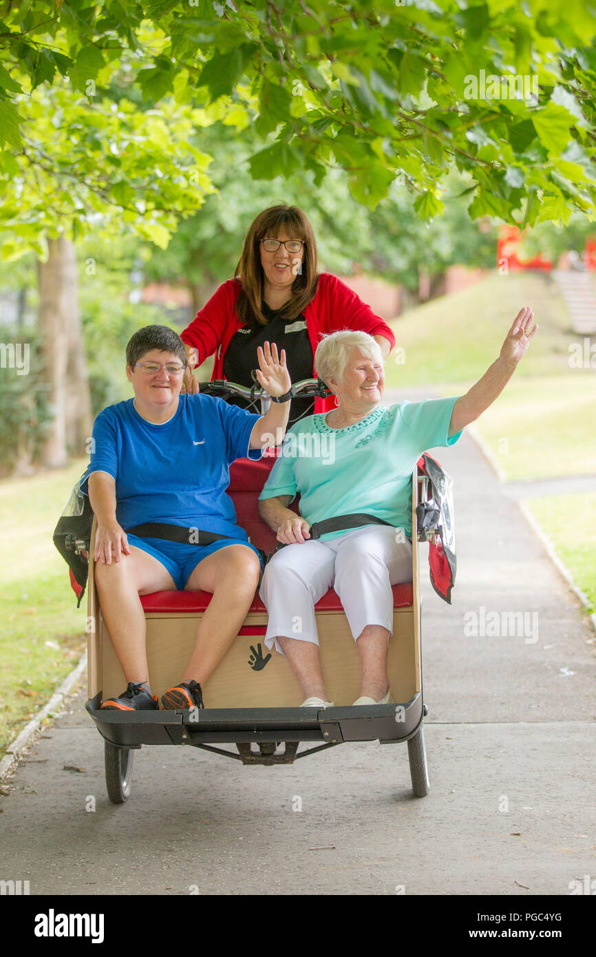 Les femmes âgées d'obtenir un tour sur un vélo Banque D'Images