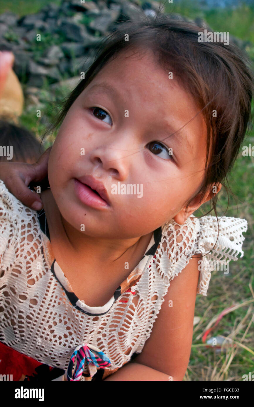 Un iimpoverished jeune fille jouit de sa journée dans un bidonville de Kampong Cham, au Cambodge. Banque D'Images
