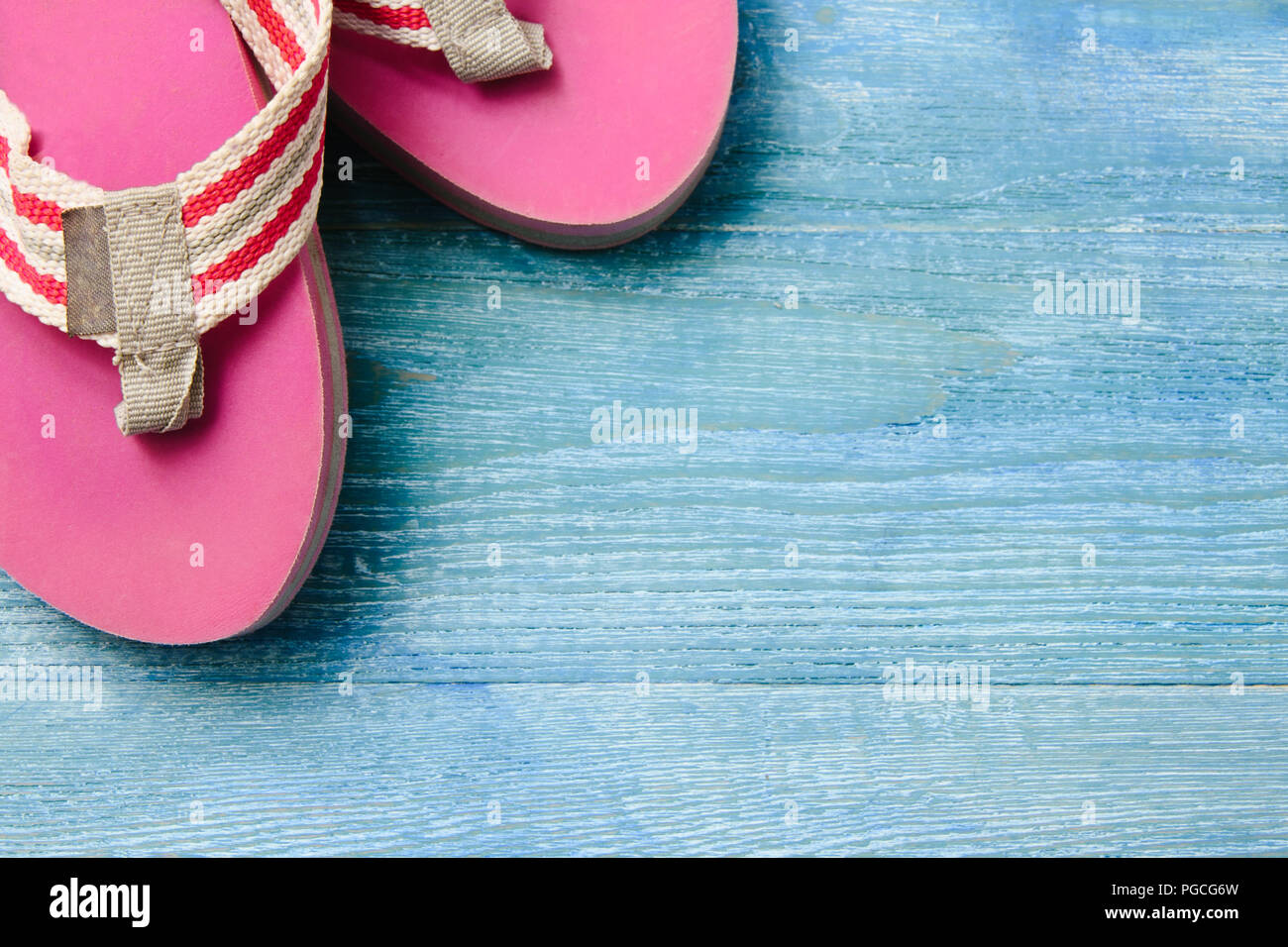 Chaussons rose sur un fond de bois bleu, été Contexte et concept de vacances Banque D'Images