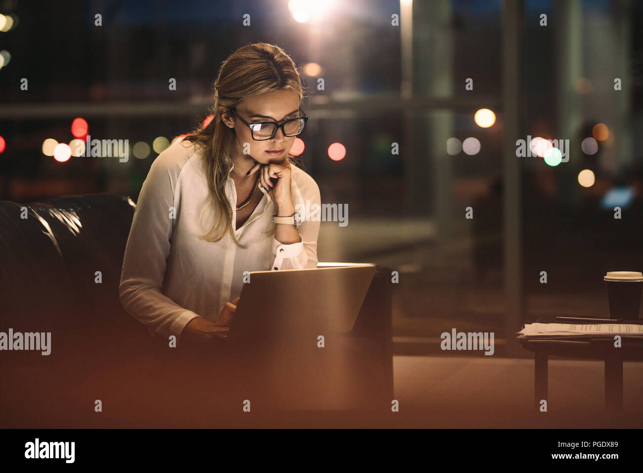 Femme d'affaires travailler tard sur ordinateur portable. Femme d'affaires à l'aide d'un ordinateur portable au bureau. Banque D'Images