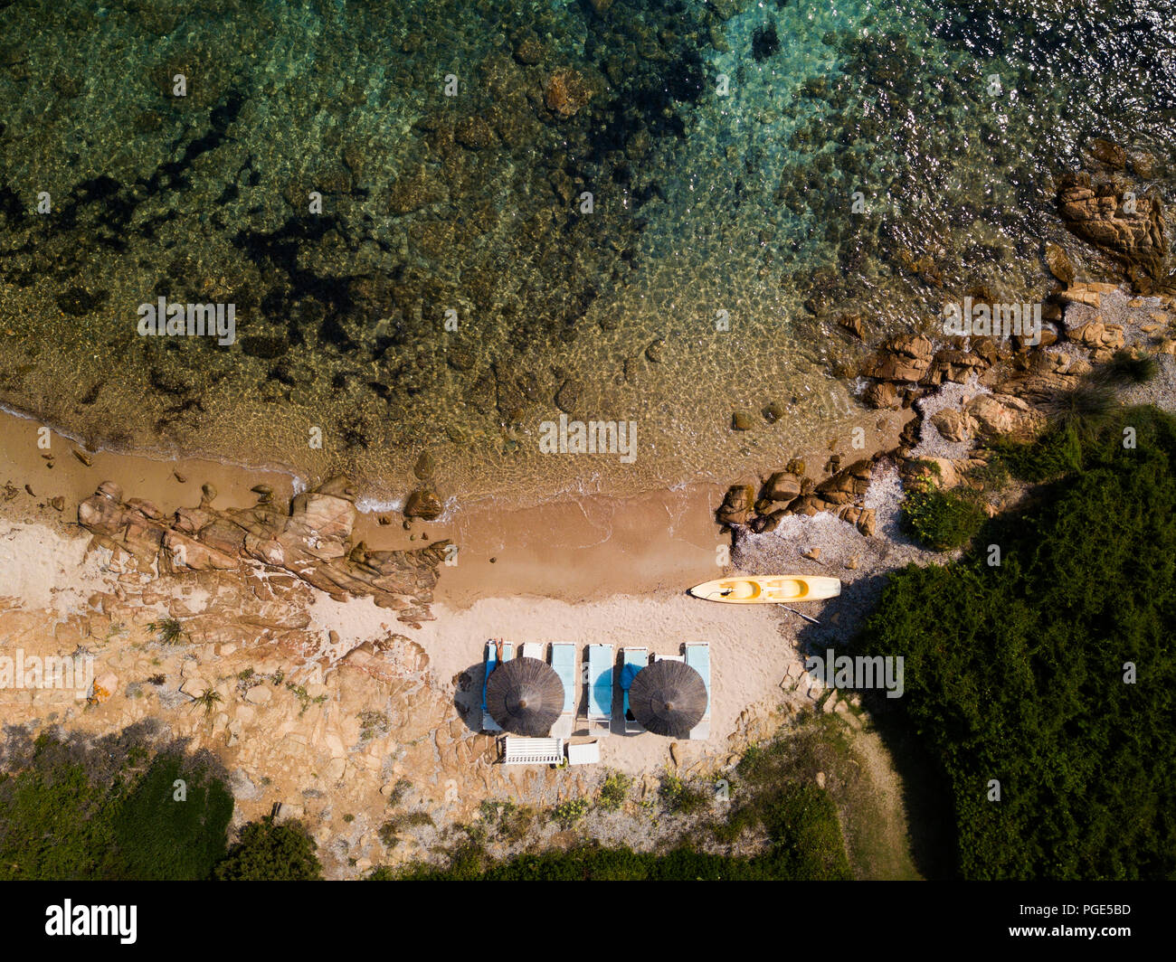 Vue aérienne de deux parasols sur une belle petite plage baignée par une belle mer turquoise. Sardaigne, Italie. Banque D'Images